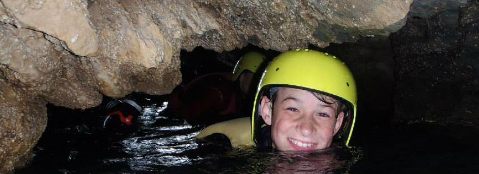 school kids coasteering in a cave