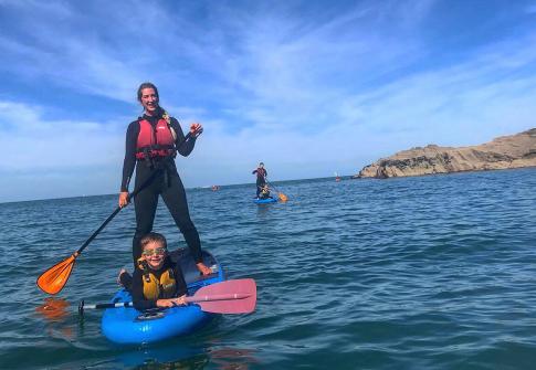 mum and child on paddleboarding in the sea