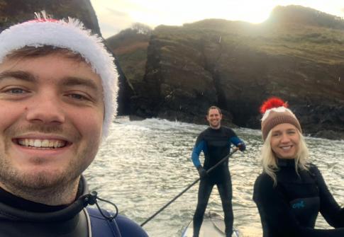 people paddleboarding at christmas wearing christmas hats