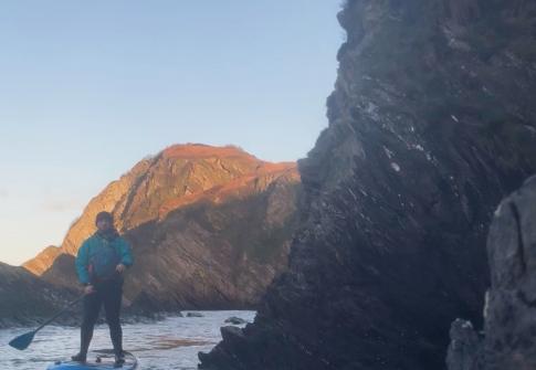 man paddleboarding in the winter
